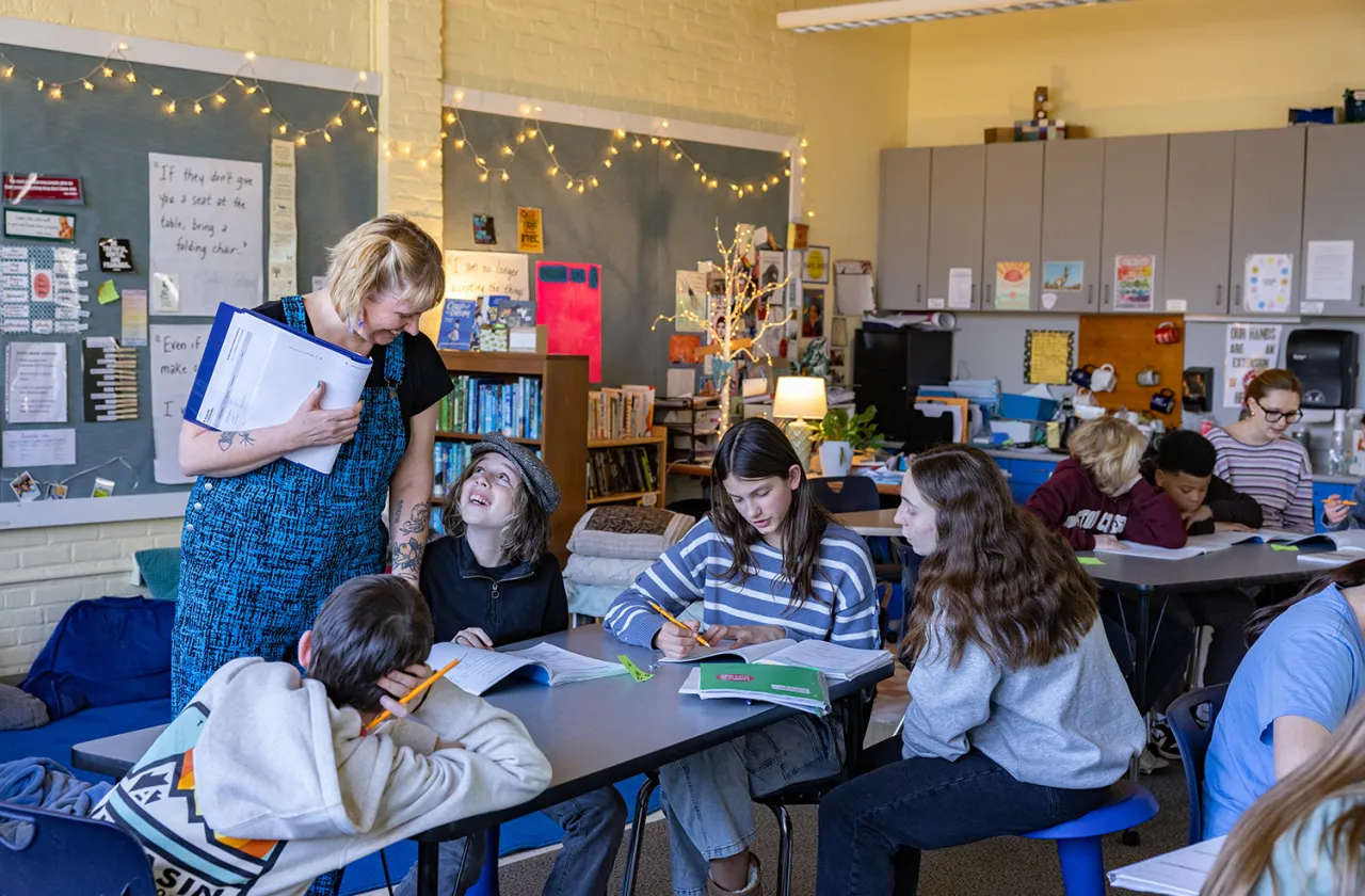 A group of students smiling up at their teacher.