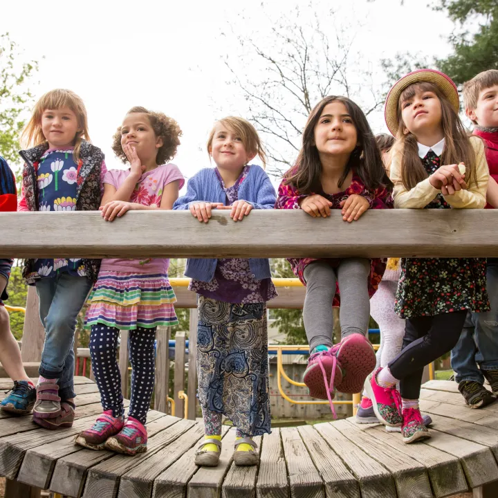 A group of schoolchildren on a wooden play structure.