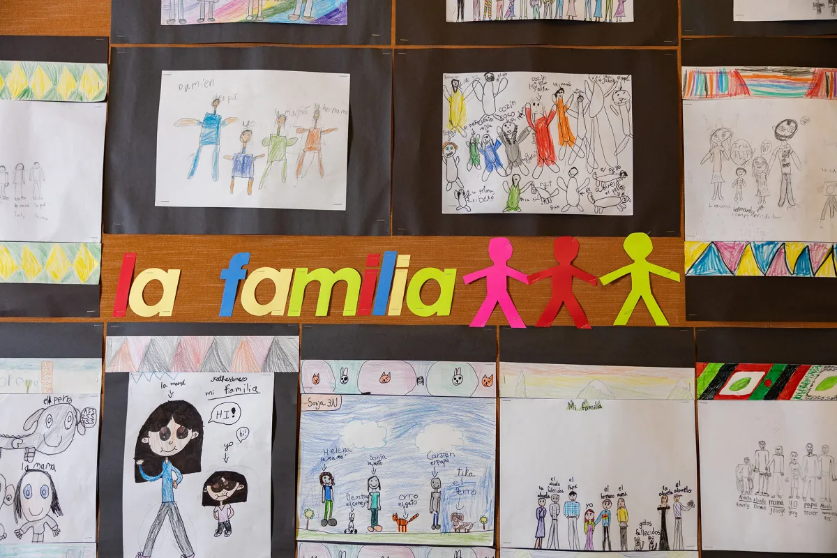 Students' artwork, drawings of their families labeled in Spanish.